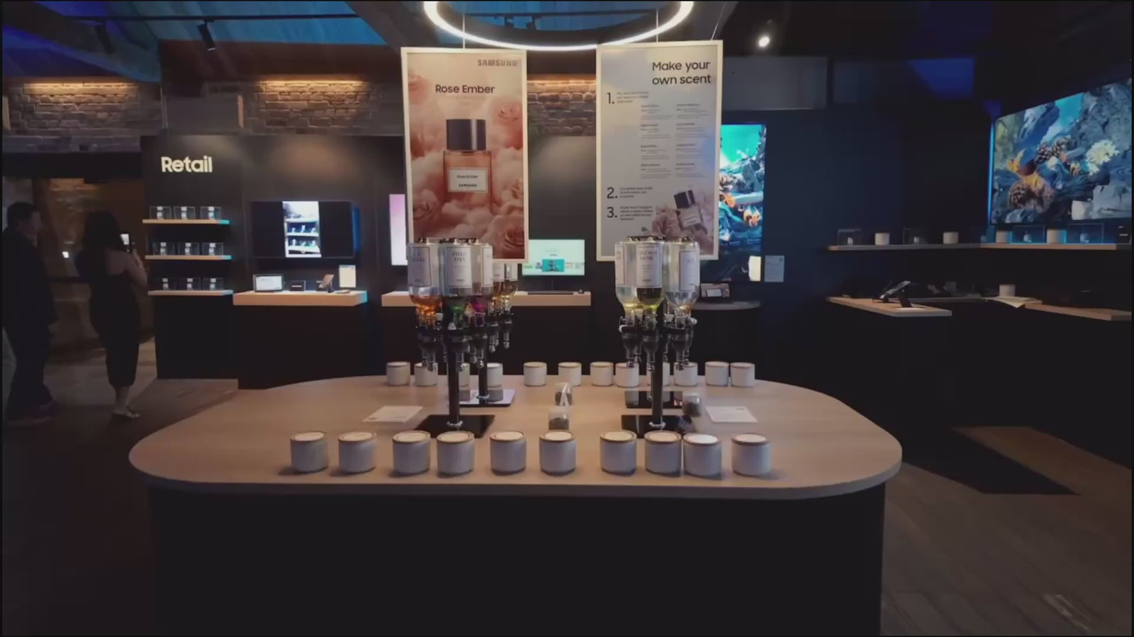 Interactive perfume bar station with digital signage and fragrance dispensers at a high-tech Samsung brand activation event